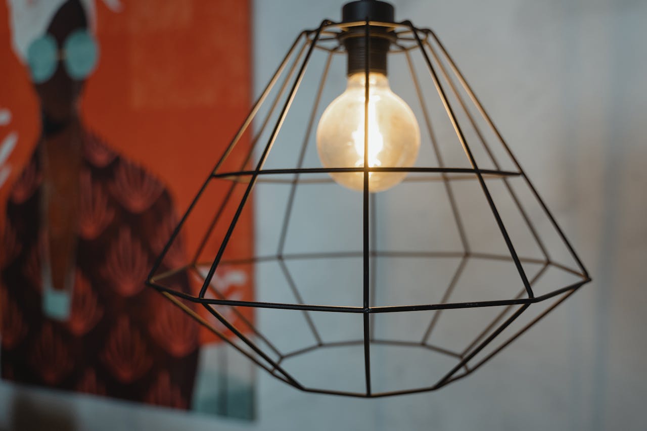 Close-up of a geometric lamp with a warm glow against an artistic background.